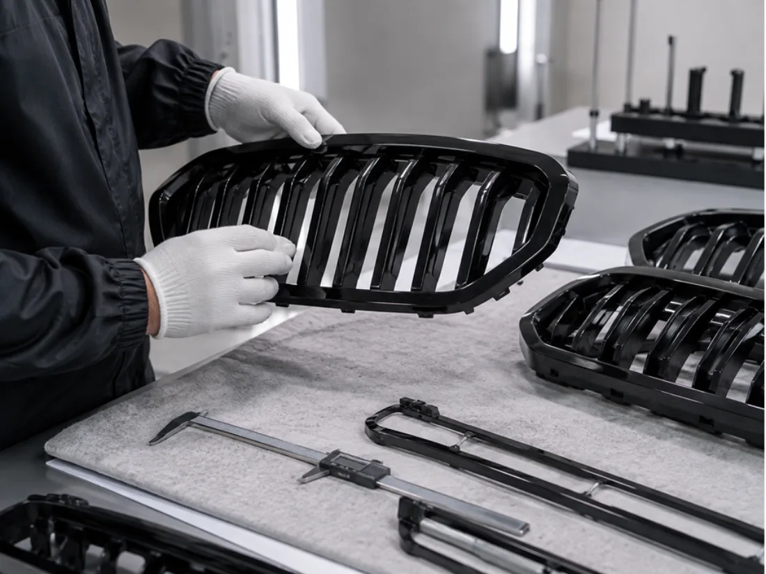 Gloved hands checking a painted grille against a caliper